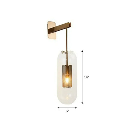 A modern brass glass wall sconce with wire mesh guard and clear cylinder bulb housing for 110v-120v use