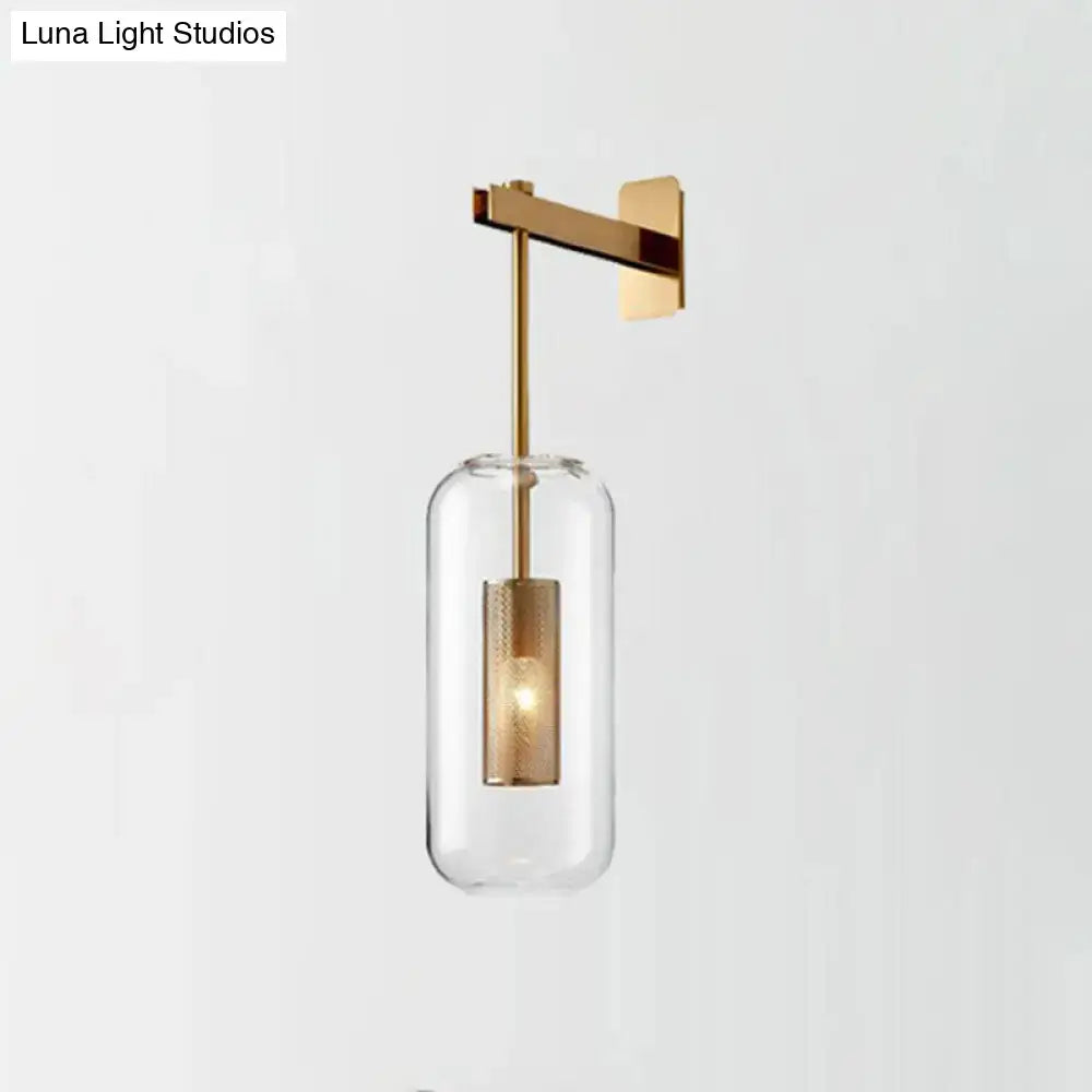 Modern brass glass wall sconce with gold-toned wire mesh guard and clear cylindrical shade for 110v-120v use