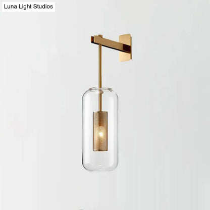Modern brass glass wall sconce with gold-toned wire mesh guard and clear cylindrical shade for 110v-120v use