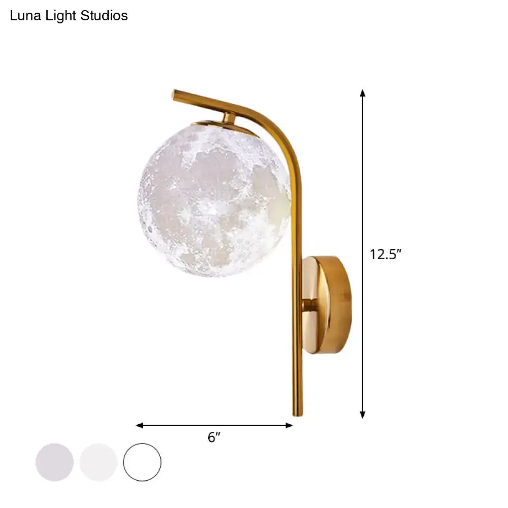 Modern brass globe bedside lamp with a gold-toned inch fixture and frosted moon-like glass globe featuring crater patterns