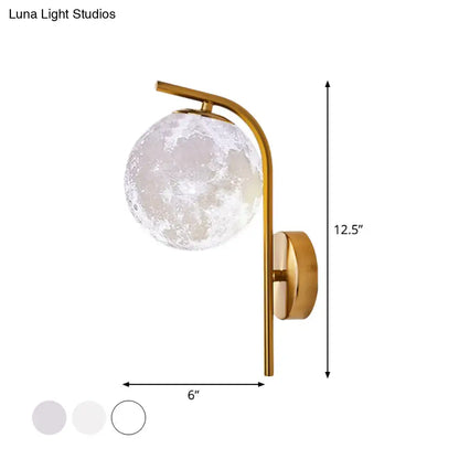 Modern brass globe bedside lamp with a gold-toned inch fixture and frosted moon-like glass globe featuring crater patterns