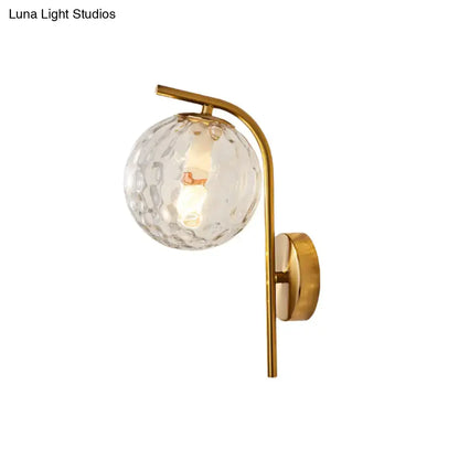 Modern brass bedside lamp with gold-toned wall sconce and textured clear glass globe 8 inch fixture for bedroom use