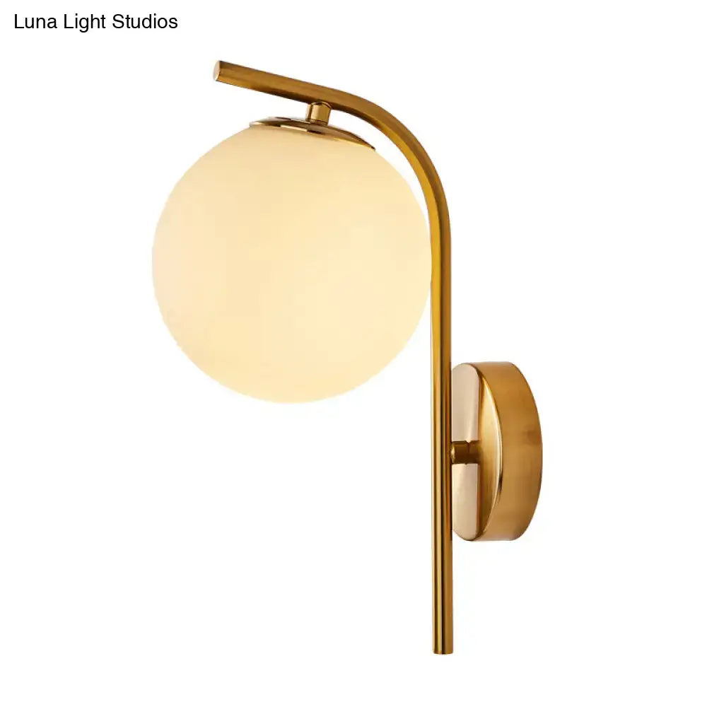 Modern brass bedside lamp with gold-toned inch fixture and spherical frosted glass shade for bedroom use