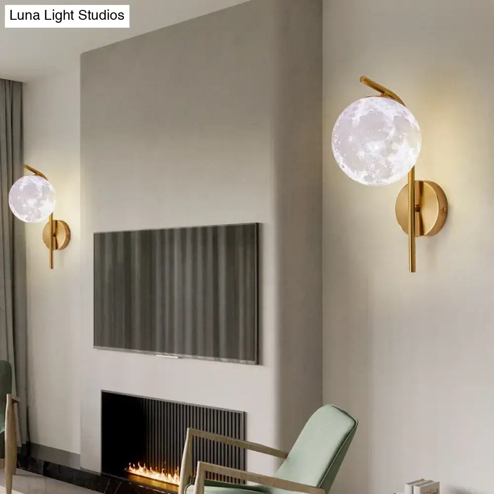 Modern brass globe bedside lamp with gold-toned inch fixture and frosted glass moon-shaped globe illuminated from within