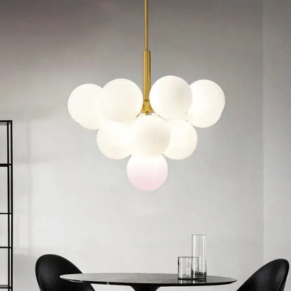 Modern brass globe pendant lamp featuring gold-toned metal and frosted white glass globes clustered together