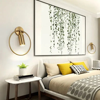 Modern brass gold adjustable led wall sconce with circular base and cylindrical lamp head for corridor lighting