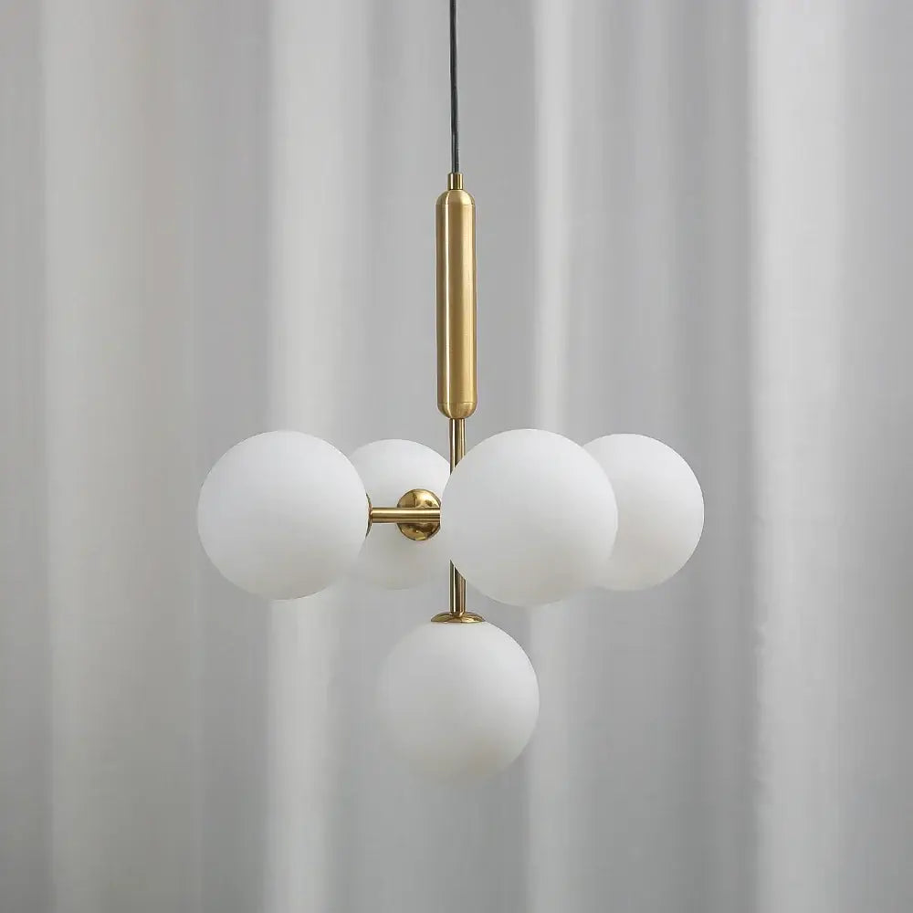 Modern brass golden glass balls ceiling light featuring five frosted white glass spheres on polished brass rod decorbites ceiling light