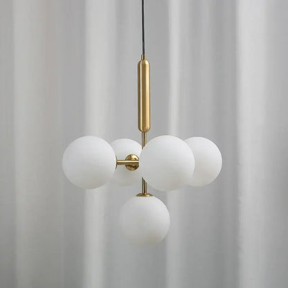 Modern brass golden glass balls ceiling light featuring five frosted white glass spheres on polished brass rod decorbites ceiling light