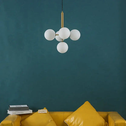 Modern brass golden glass balls ceiling light featuring five frosted glass spheres on a gold-toned metal rod decorbites golden glass ceiling light