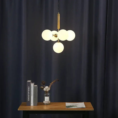 Modern ceiling light with five frosted golden glass balls on brass rod by decorbites for dining room decor