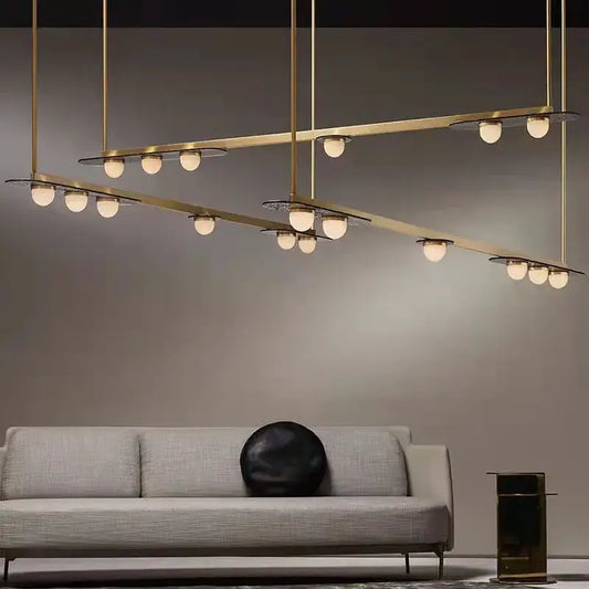 Modern brass pendant light fixture with multiple spherical gray glass led bulbs in intersecting horizontal bars