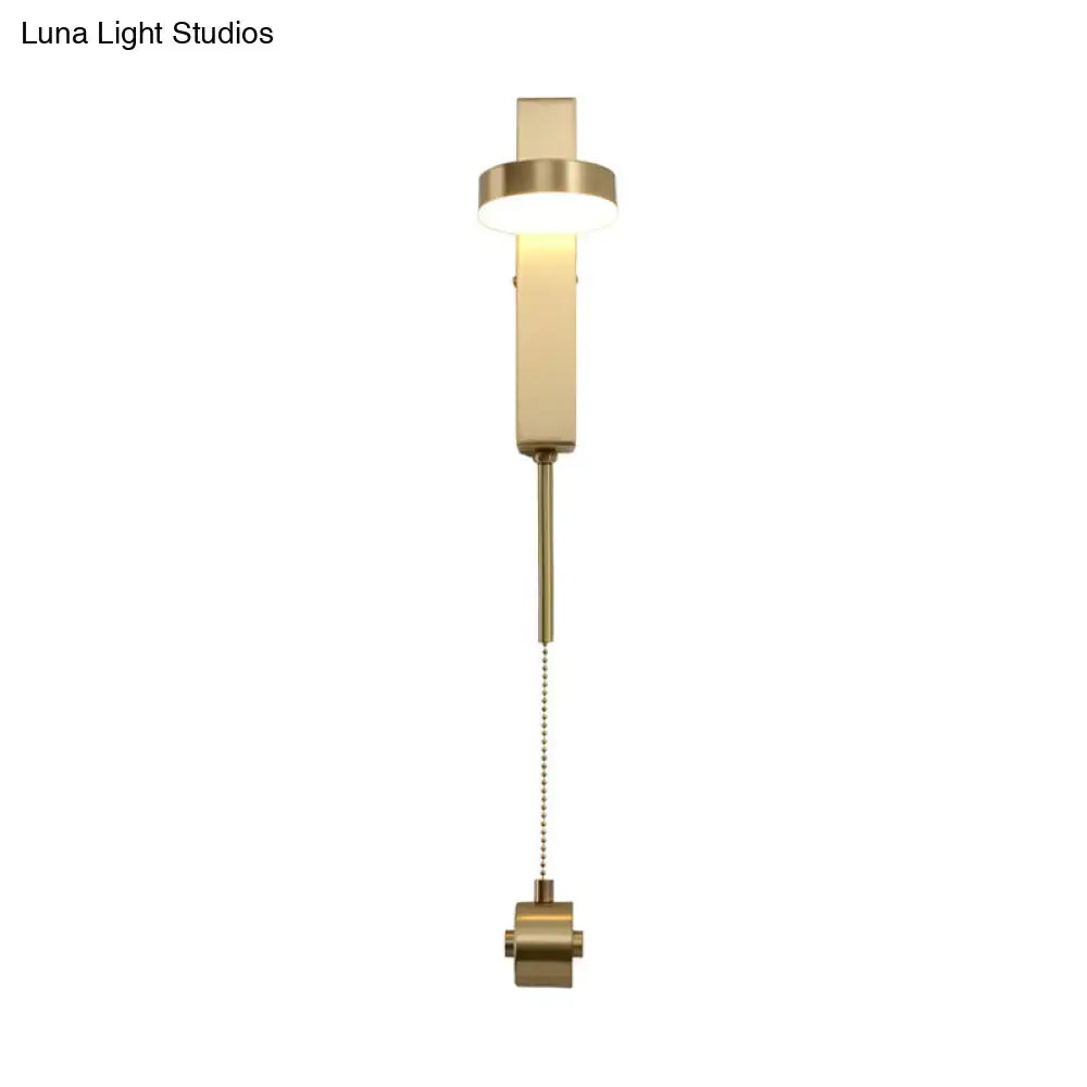 Modern brass l-shaped wall sconce with pull chain featuring a sleek rectangular design for living room use