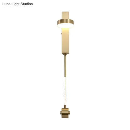Modern brass l-shaped wall sconce with pull chain featuring a sleek rectangular design for living room use