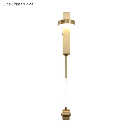Modern brass l-shaped wall sconce with pull chain featuring a sleek rectangular design for living room use