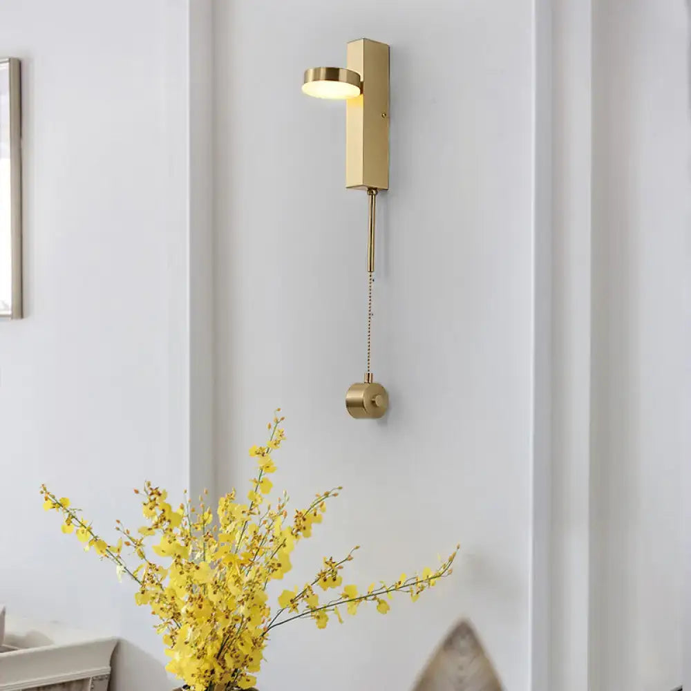 Modern brass l-shaped wall sconce with gold finish, adjustable head, and pull chain for living room lighting
