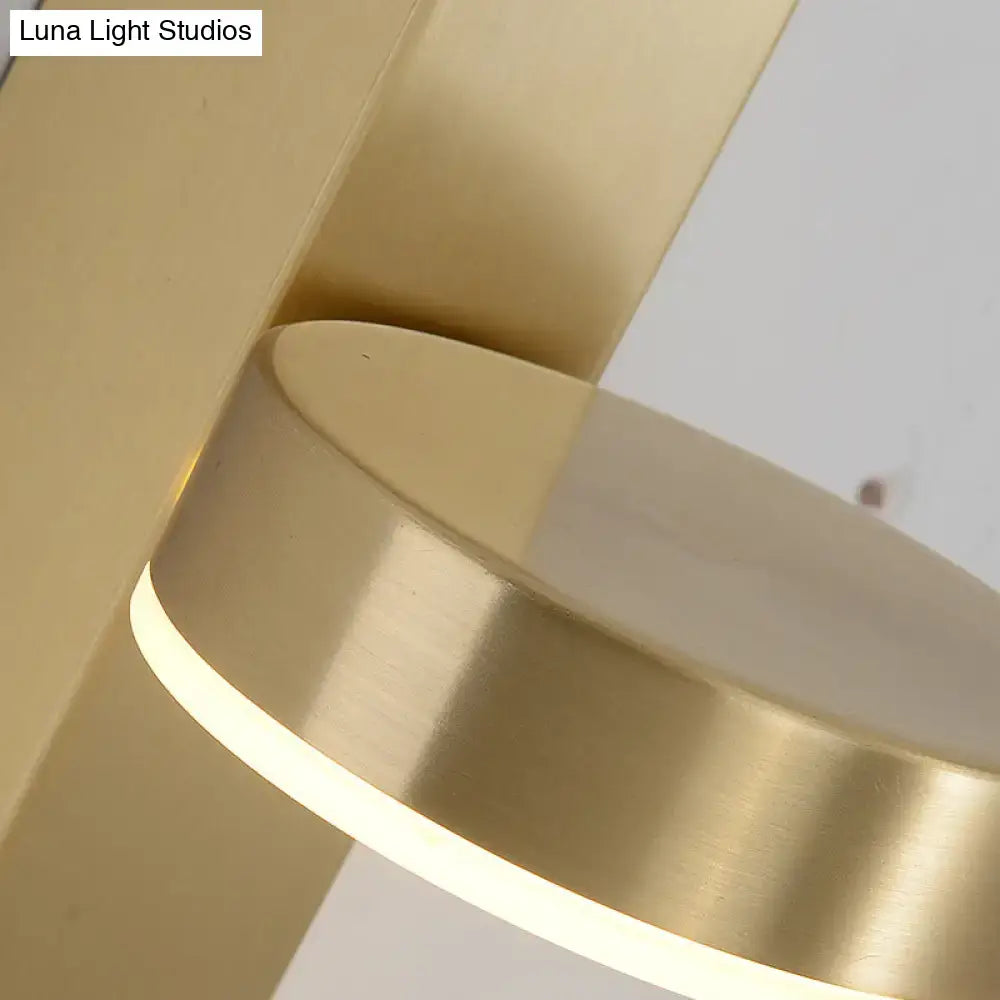 Modern brass l-shaped wall sconce with gold-toned circular pendant light and pull chain for living room lighting