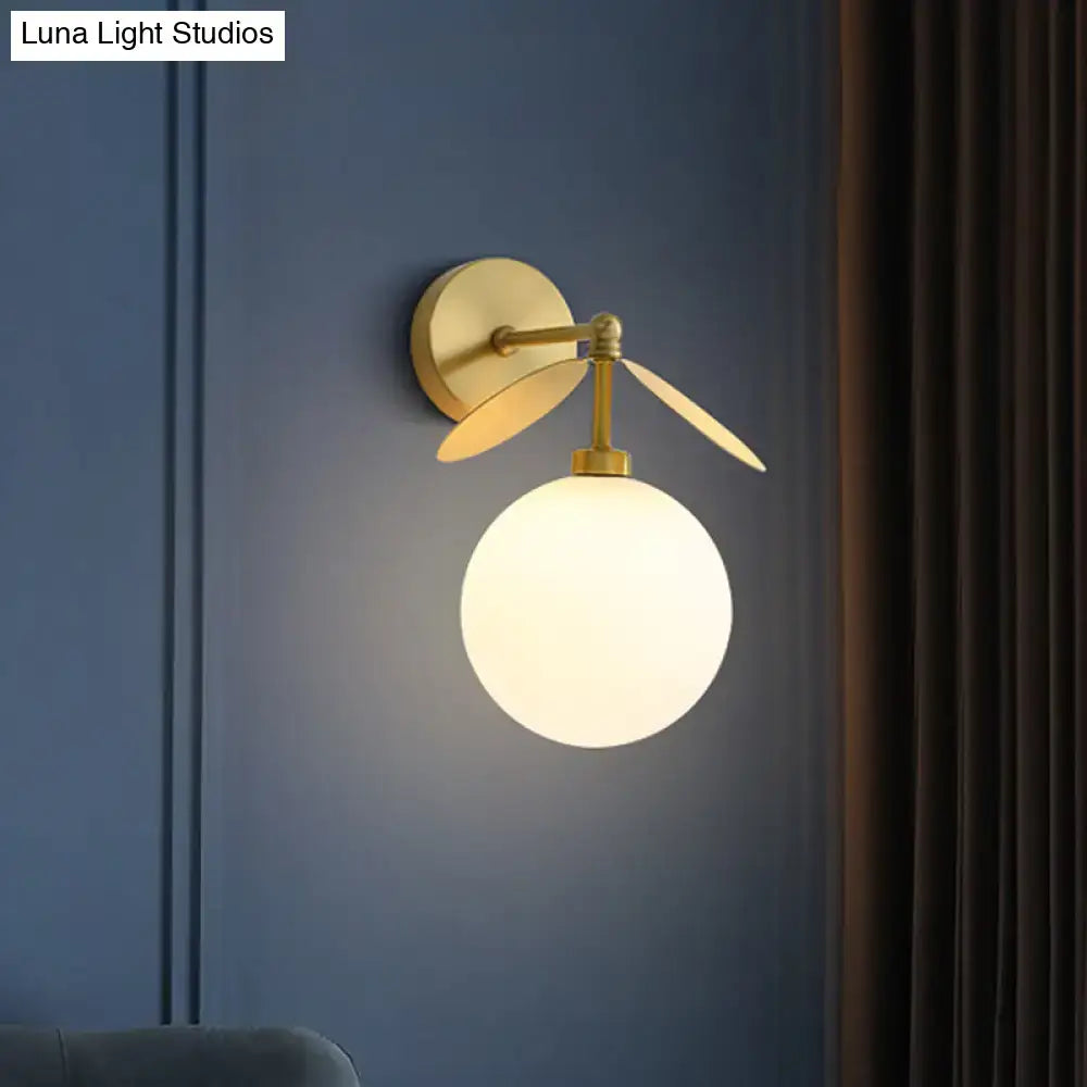 Modern brass leaf wall lamp with gold-toned arms and cream glass spherical shade for 220v-240v 110v-120v use
