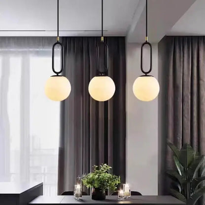 Three modern brass led pendant lights with black metal frames and frosted glass globes for kitchen decorbites brass led
