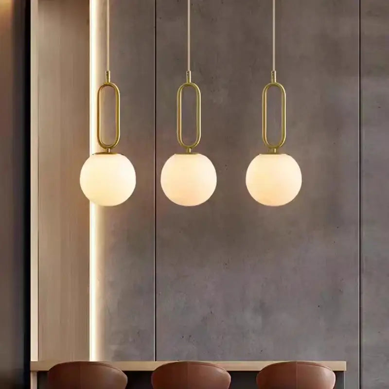 Three modern brass led pendant lights with gold-toned oval frames and frosted glass globes for kitchen decorbites decor
