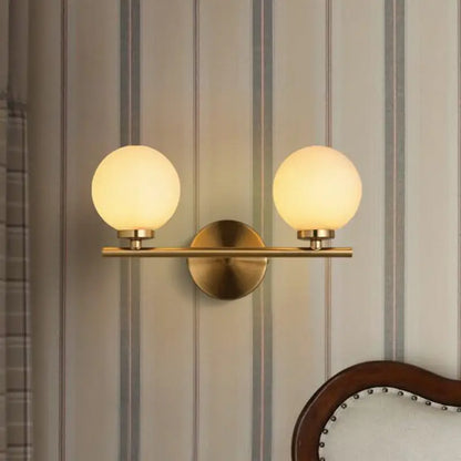 Modern brass light fixture bedroom sconce with frosted glass product shade and two product bulb globes
