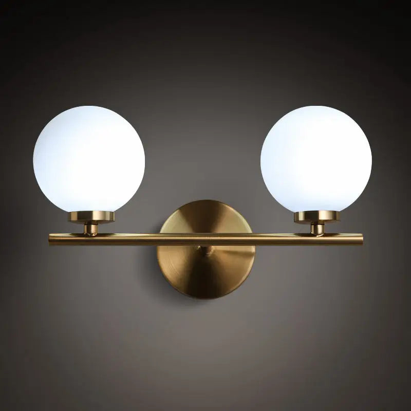 Modern brass light fixture with two frosted glass product shade globes for bedroom sconce lighting with product bulb