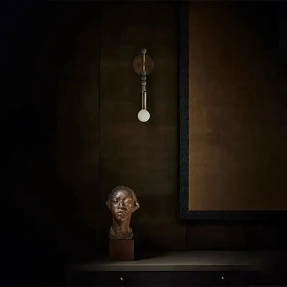 Bronze-colored sculpted bust on dark wooden base complements modern brass marble ball wall sconce bedroom led light decorbites brass marble