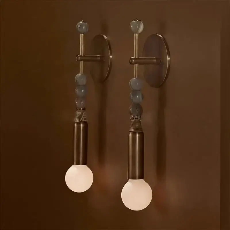 Pair of modern brass marble ball wall sconces with bronze finish, gray beads, and natural fiber cord for bedroom decorbites brass marble