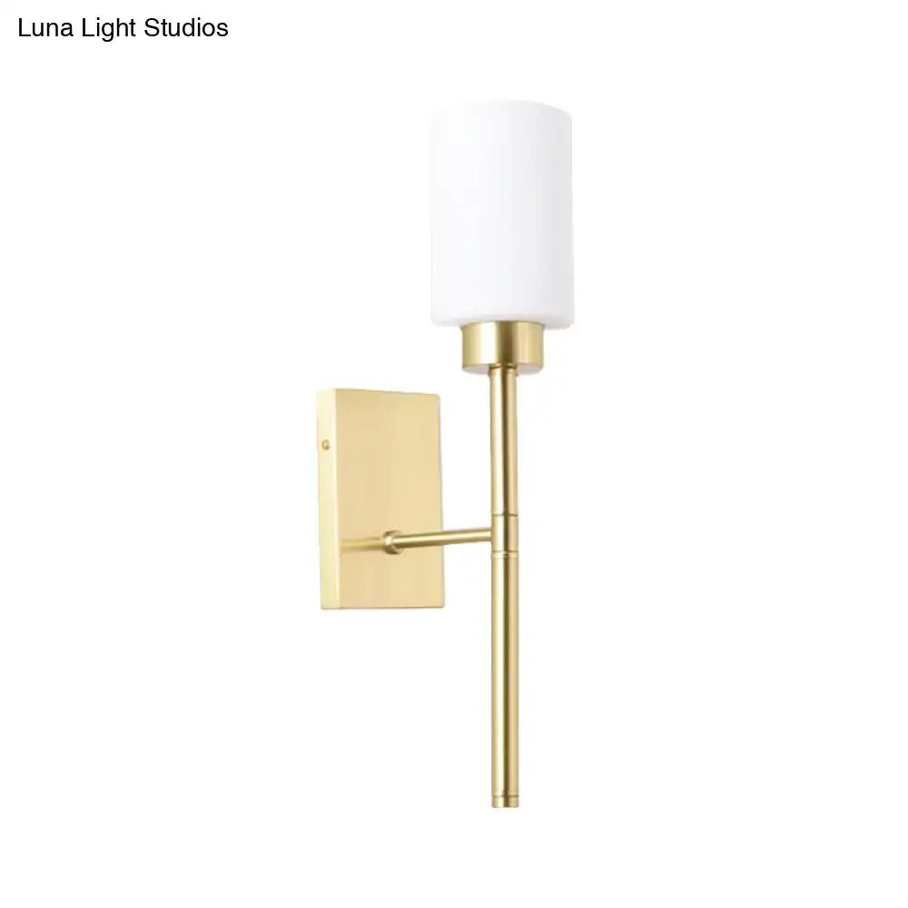 Modern brass wall light with gold finish and opal glass tube cylindrical shade for bedroom sconce lighting