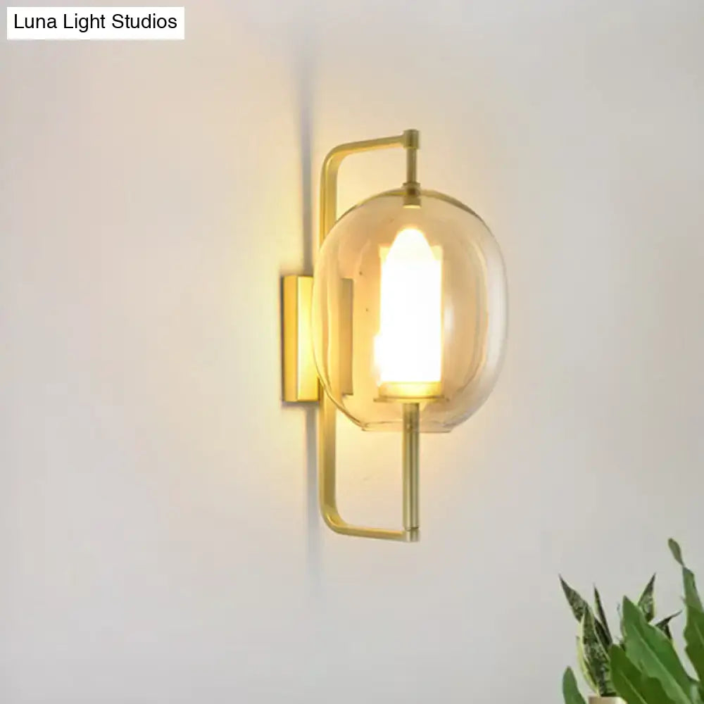 Modern brass wall sconce with an oval clear glass shade gold-toned metal frame perfect for bedroom lighting
