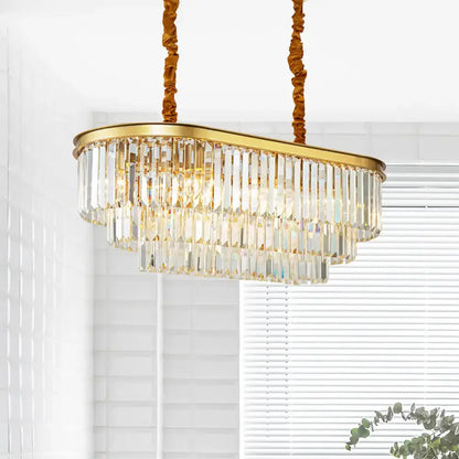 Modern brass oval crystal chandelier with gold finish and cascading prisms for elegant dining room hanging light