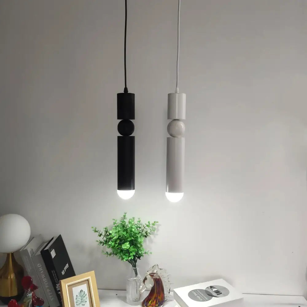 Two minimalist pendant lights in black and matte gray with stacked geometric shapes for modern kitchen decorbites brass pendant