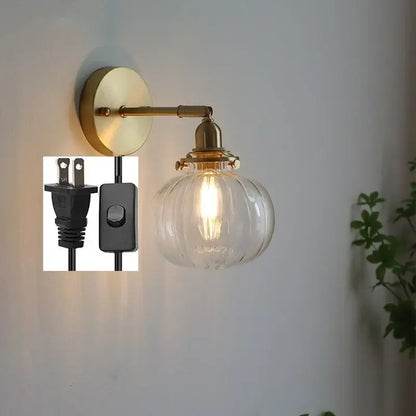 Modern brass ribbed glass ball wall sconce featuring a clear glass ball with exposed filament bulb for bedroom lighting decorbites glass ball wall