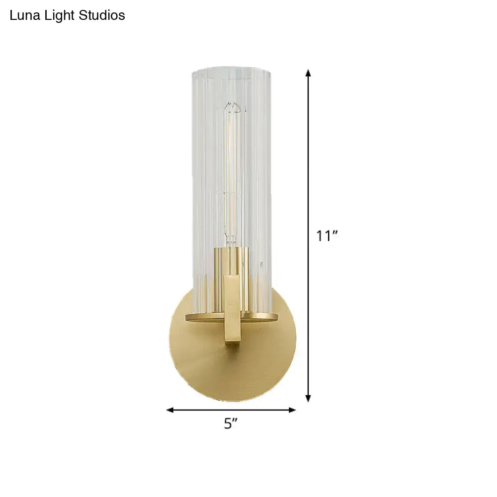 Modern brass ribbed glass shade wall sconce with brushed gold finish and clear cylindrical glass shade for bedroom lighting