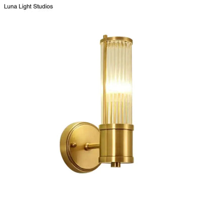 Modern brass ridged crystal wall light with gold finish and cylindrical vertically ribbed glass shade as a hallway fixture height