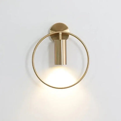 Modern brass ring led wall lamp featuring a circular brass sconce with a cylindrical led wall light fixture for bedroom use