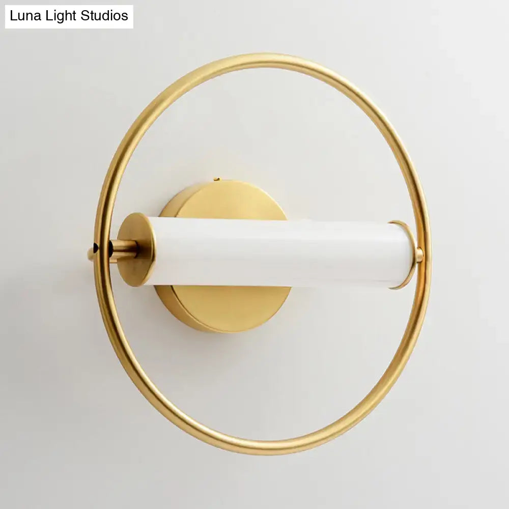 Modern brass ring wall sconce with gold tone and sleek white opal glass shade for bedroom lighting