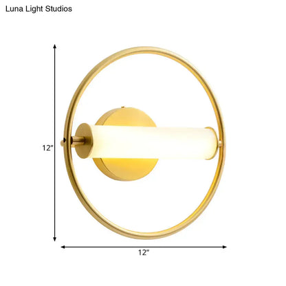 Modern brass ring wall sconce with gold-toned circular design and illuminated opal glass shade for bedroom lighting