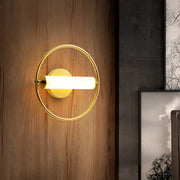 Modern brass ring wall sconce with gold-toned finish and opal glass shade featuring a sleek cylindrical light fixture
