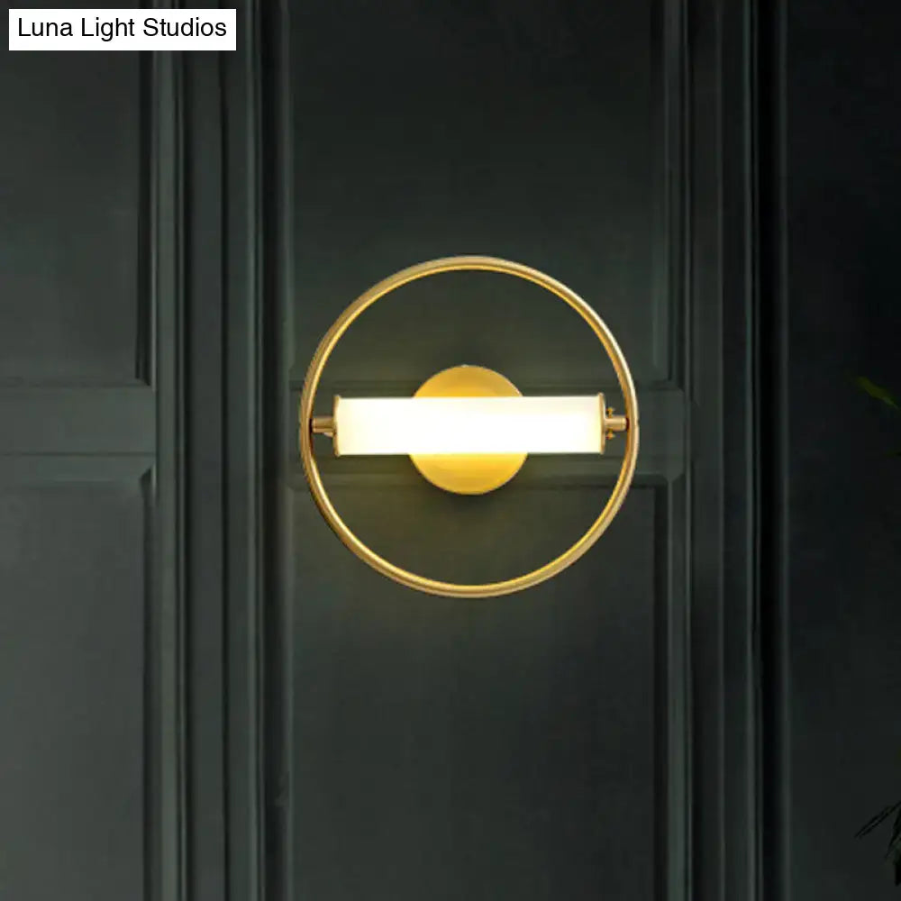 Modern brass ring wall sconce with gold-toned finish featuring an illuminated rectangular light bar and opal glass shade