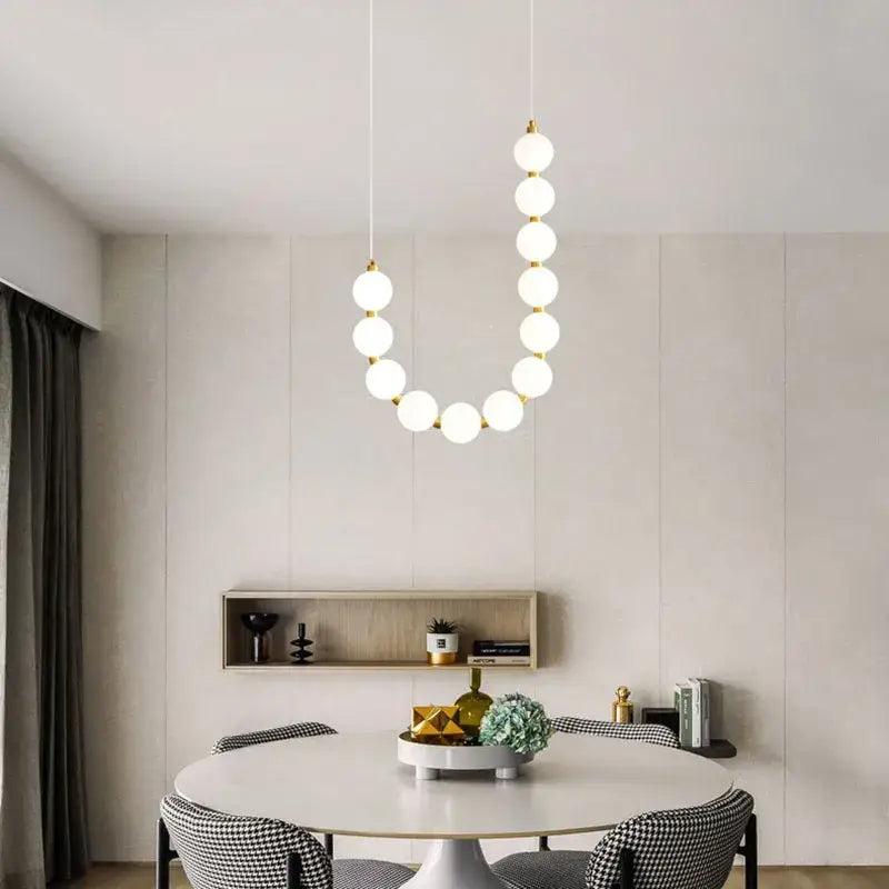 Modern brass round led pendant lights featuring white spherical bulbs and gold-toned fixtures for dining room decorbites brass round chandelier
