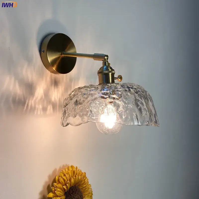 Modern brass wall sconce with decorbites clear glass led shade featuring textured clear glass and ornate ruffled edge