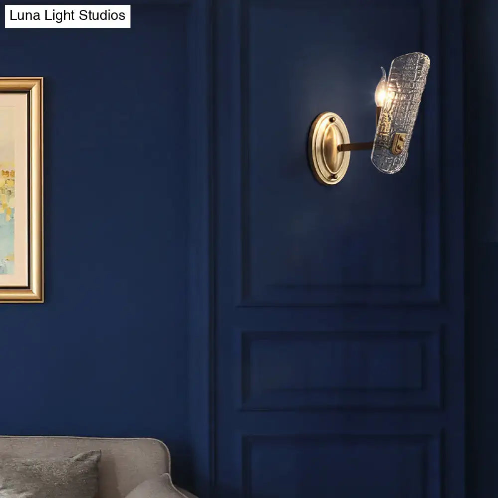 Modern brass sconce with gold-toned finish and clear water glass textured shade for living room two lights