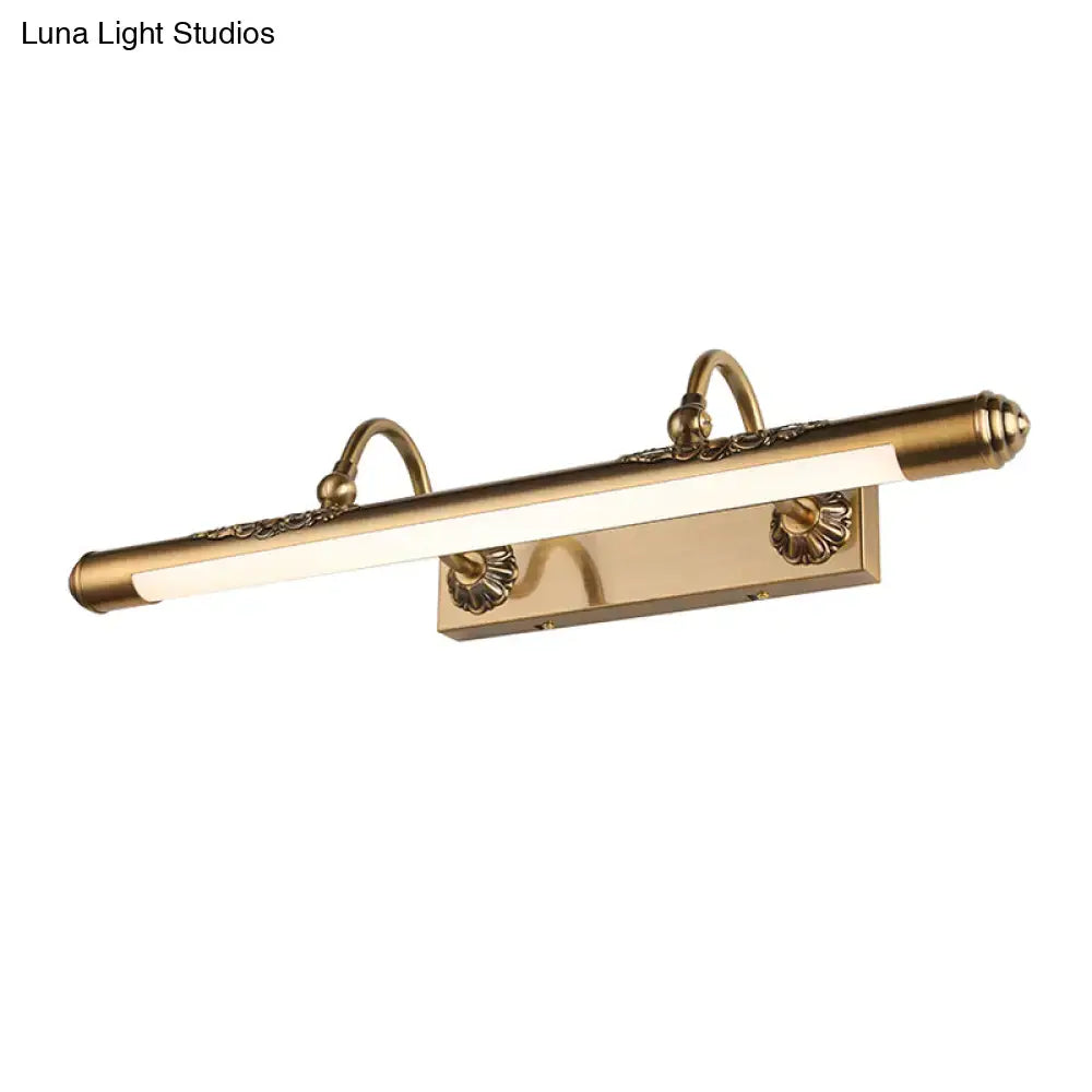 Antique brass-finished wall mount light with ornate floral detailing and sleek elongated rectangular design for bathroom vanity