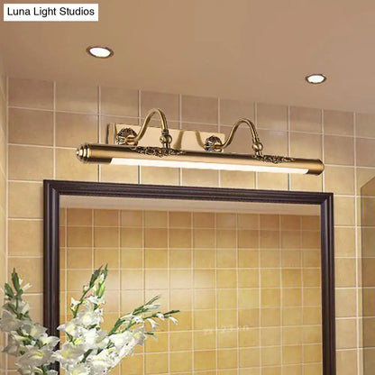 Antique brass-finished wall mount light with ornate scrollwork and sleek rectangular design for bathroom vanity use