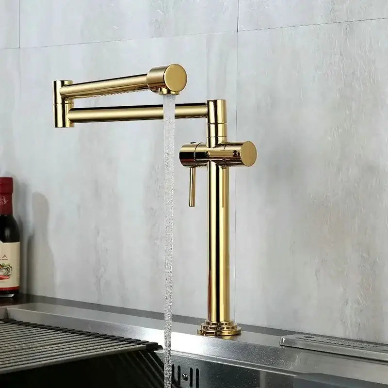 Modern brass single handle kitchen faucet with gold-colored sleek articulated mixer tap and extendable spout