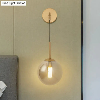 Modern brass smoked glass ball wall hanging lamp with gold-toned spherical glass ball wall and frosted finish