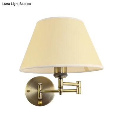 Antique brass wall-mounted swing arm paper lamp with cream fabric shade ideal for living room use