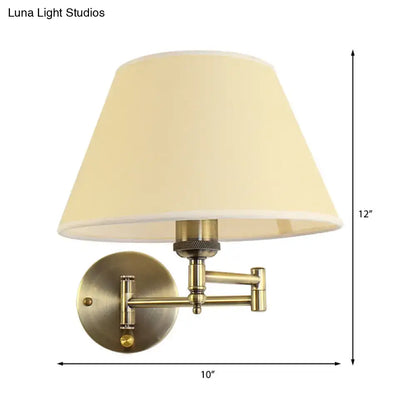 Antique brass wall sconce with cream fabric shade featuring modern brass swing arm paper wall mount design