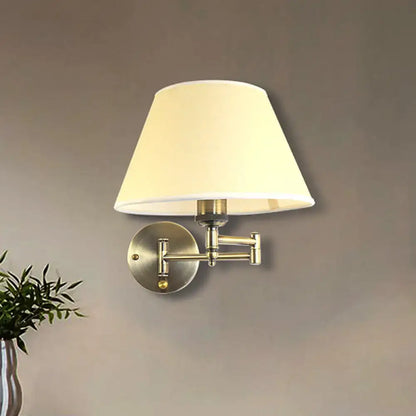 A modern brass swing arm paper wall mount lamp with brushed brass finish and soft white fabric shade for living room