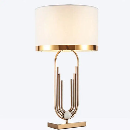 Modern decorbites brass table lamp with gold-toned metal base and off-white cylindrical fabric shade for bedroom decor